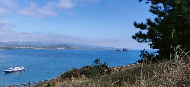 Landscape view of blue sea and sky with boat seen from songaksan mountain in Jeju Island, South Korea