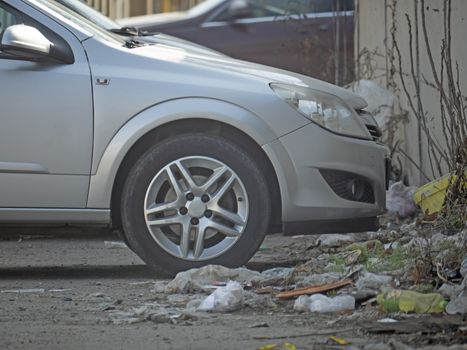 silver color car parked beside the garbage