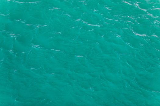 Background shot of aqua sea water surface. Sea surface aerial view. Waving water surface of the sea background.