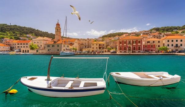 Panorama of picturesque town Pucisca in Croatia, Island Brac, Europe. Pucisca town mediterranean panorama with seagull's flying over the town. Croatia, Island Brac, Europe.