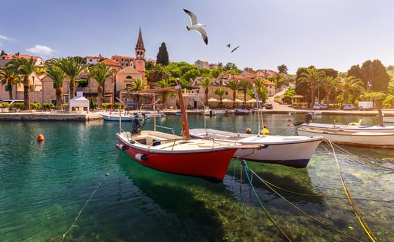 Splitska village with beautiful port and seagull's flying over the village, Brac island, Croatia. Fishing boats in Splitska village on Brac island seafront view, Dalmatia, Croatia, Croatia.