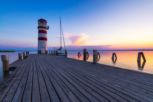 Lighthouse at Lake Neusiedl, Podersdorf am See, Burgenland, Austria. Lighthouse at sunset in Austria. Wooden pier with lighthouse in Podersdorf on lake Neusiedl in Austria.