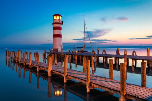 Lighthouse at Lake Neusiedl, Podersdorf am See, Burgenland, Austria. Lighthouse at sunset in Austria. Wooden pier with lighthouse in Podersdorf on lake Neusiedl in Austria.
