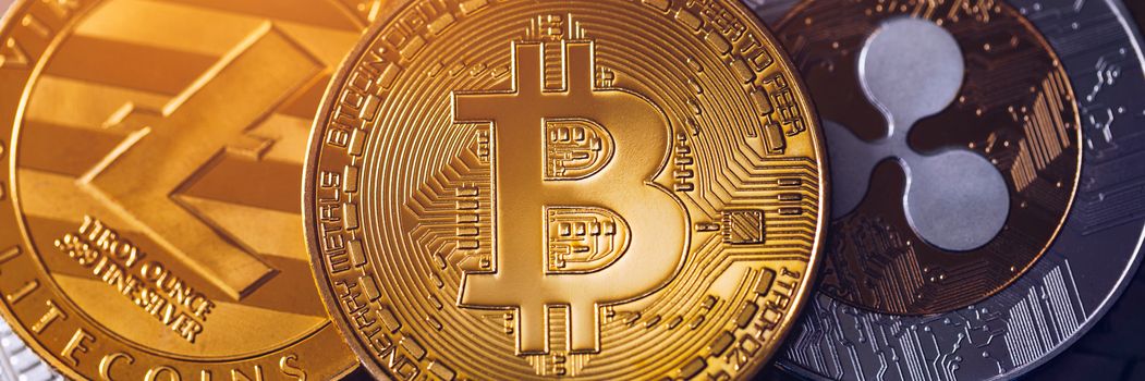 Bitcoin, litecoin and ripple coins currency finance money on graph chart background. Bitcoin as most important cryptocurrency concept. Stack of cryptocurrencies with a golden bitcoin in the middle.
