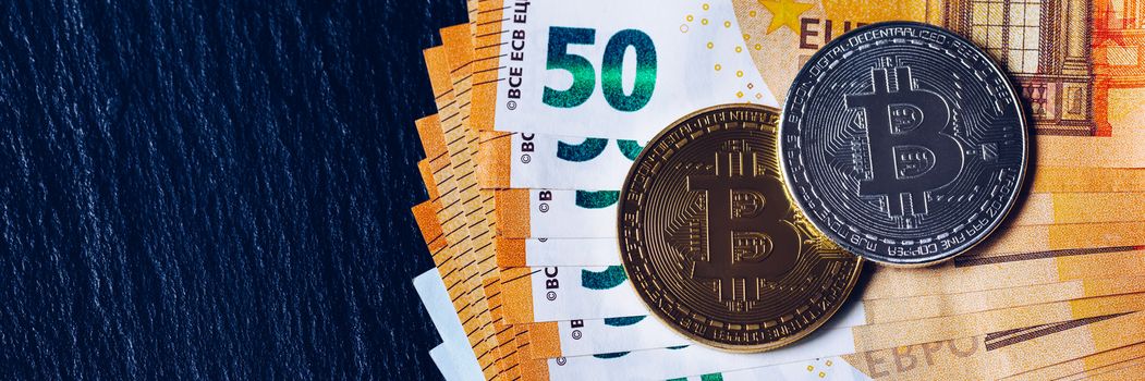 Golden bitcoin over Euro money. Bitcoin cryptocurrency. Crypto currency concept. Bitcoin with euro bills. Bitcoins stacked on euro banknotes.