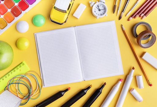 Back to school concept. School and office supplies on yellow table. Flat lay with copy space.