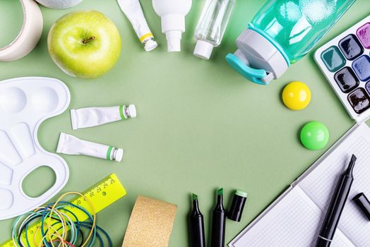 Back to school concept. School and office supplies on green background. Flat lay with copy space.