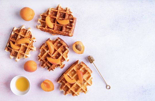 belgian waffles with fresh peach and honey on white background top view flat lay with copy space