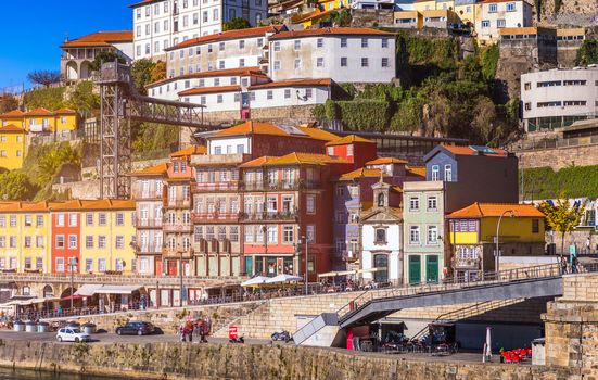 Colorful houses of Porto Ribeira, traditional facades, old multi-colored houses with red roof tiles on the embankment in the city of Porto, Portugal