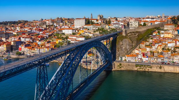 Porto panoramic aerial view of Dom Luis Bridge and houses with red roof tiles in a beautiful summer day. Porto, Portugal