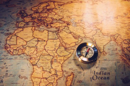 Old vintage retro golden compass on ancient map. Selective focus, shallow depth of field. Concept of world travel, sightseeing and tourism.