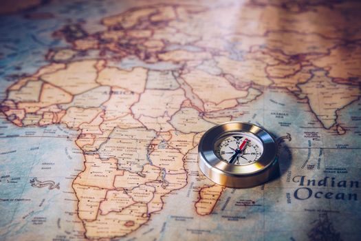 Old vintage retro golden compass on ancient map. Selective focus, shallow depth of field. Concept of world travel, sightseeing and tourism.