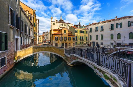 Street canal in Venice, Italy. Narrow canal among old colorful brick houses in Venice, Italy. Venice postcard