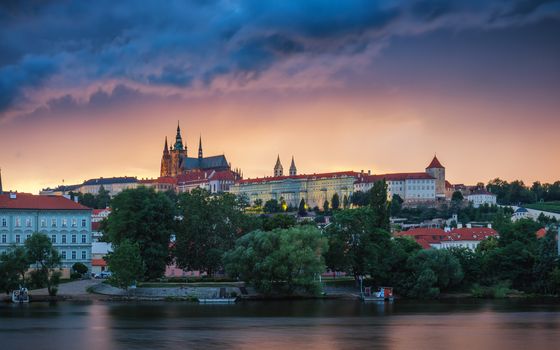 Prague old town including Prague castle in the background, one of the most famous landmarks of Prague at sunset with dramatic sky.