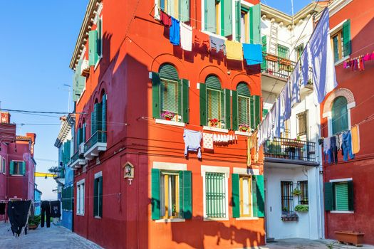 Street with colorful buildings in Burano island, Venice, Italy. Architecture and landmarks of Burano, Venice postcard. Scenic canal and colorful architecture in Burano island near Venice, Italy