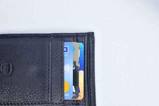 Debit and Credit cards in black color wallet on white background. Top view.