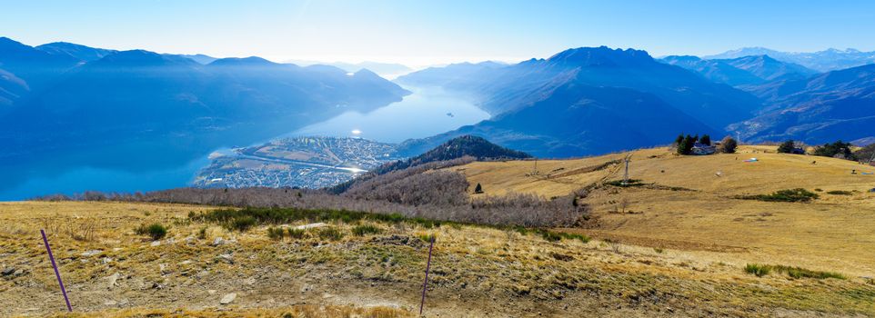 Panoramic view of Locarno and Lake Maggiore from the Cardada-Cimetta mountain range, with a chairlift and a paraglider. Ticino canton, Switzerland