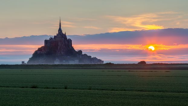 Beautiful panoramic view of famous Le Mont Saint-Michel tidal island at sunrise. Normandy, northern France