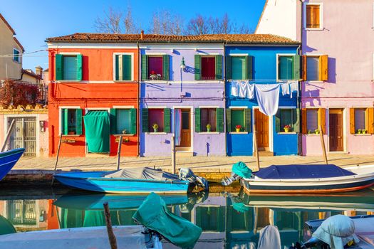 Beautiful view of the canals of Burano with boats and beautiful, colorful buildings. Burano village is famous for its colorful houses. Venice, Italy.