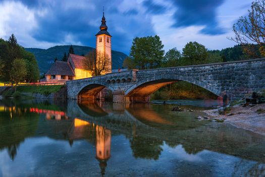 Church of Sv. John the Baptist and a bridge by the Bohinj lake in night, Slovenia. Church of St John the Baptist with bridge. Triglav National Park, Julian Alps, Slovenia, Europe