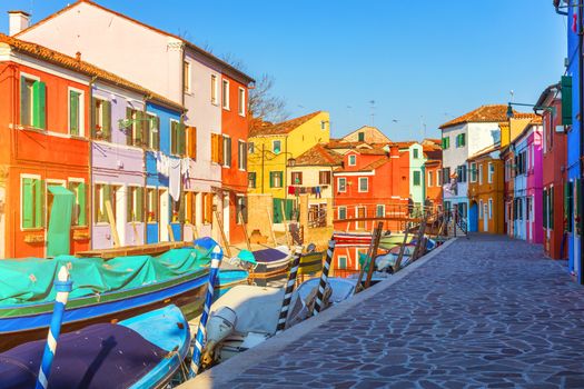 Beautiful view of the canals of Burano with boats and beautiful, colorful buildings. Burano village is famous for its colorful houses. Venice, Italy.