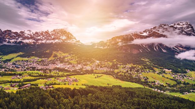 Cortina d'Ampezzo town panoramic view with alpine green landscape and massive Dolomites Alps in the background. Province of Belluno, South Tyrol, Italy.