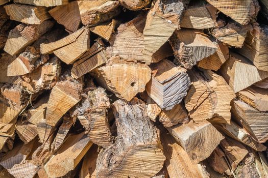 Stack of firewood, background stack of wood. Dry chopped firewood logs ready for winter