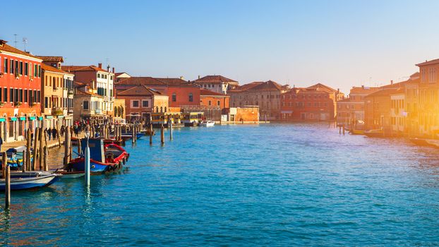 Street canal in Murano island, Venice. Narrow canal among old colorful brick houses in Murano, Venice. Murano postcard, Venice, Italy.