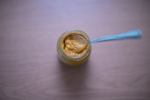 Spoon inside mustard jar shot from directly above