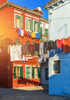 Laundry hanging out of typical houses of Burano Island, Venice, Italy. Multicolored buildings and laundry drying on the street in Burano, Venice, Italy