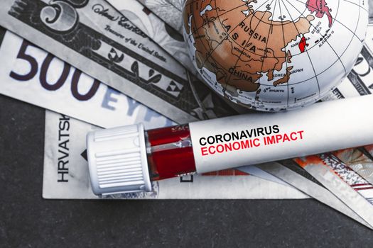 CORONAVIRUS ECONOMIC IMPACT text with currency banknotes, world globe and blood test vacuum tube on black background. Covid-19 or Coronavirus Concept 