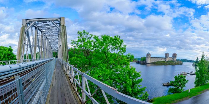 Panoramic view of a train bridge and the Olavinlinna castle in Savonlinna, Finland. It is a 15th-century three-tower castle