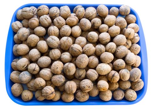 A lot of walnuts on the blue plate isolated over white. Clipping path.