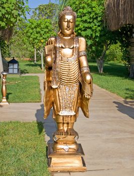 Golden meditating Buddha statue in the park.