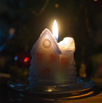 Small christmas candle house with a candlelight flame.