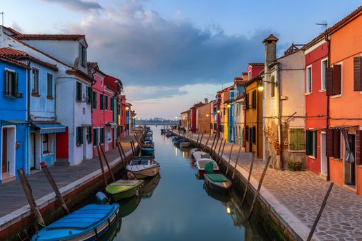Beautiful view of the canals of Burano with boats and beautiful, colorful buildings. Burano village is famous for its colorful houses. Venice, Italy.