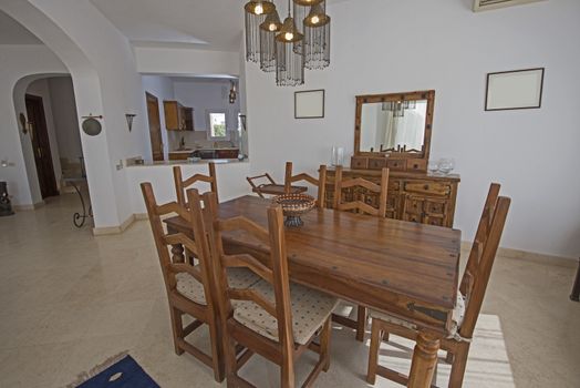 Dining area in luxury villa show home showing interior design decor furnishing with wooden dining table