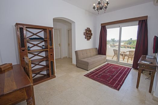 Living room lounge area in luxury apartment show home showing interior design decor furnishing and balcony