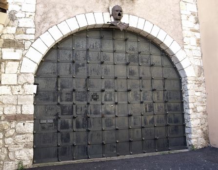 Ancient metal gate with helmet of medieval knight. La Tour Du Suquet in Cannes, France.