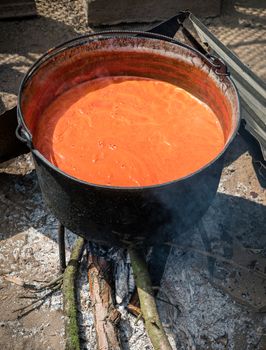 Preparing traditional romanian tomato juice/sause in caldron, boiled and preserved for the winter in a jar.