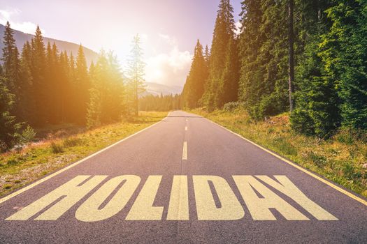 Holiday word written on road in the mountains