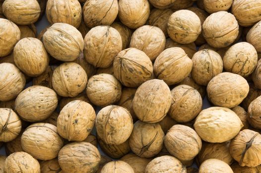 Closeup of brown raw walnuts background