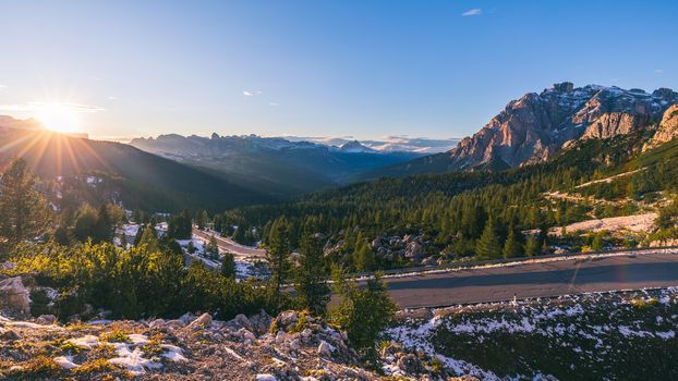 Dolomite Alps in Italy. Beautiful day. The road passes in the coniferous forests at the foot of limestone and dolomite rocks. The concept of active and car tourism