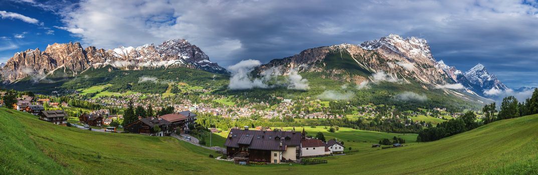 Cortina d'Ampezzo town panoramic view with alpine green landscape and massive Dolomites Alps in the background. Province of Belluno, South Tyrol, Italy.