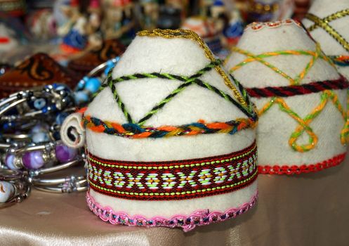 Kazakh national handicraft cap over colored background. 