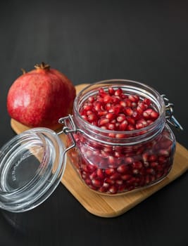 Ripe pomegranate fruit in a jar on wooden vintage background