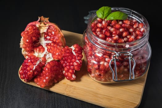 Ripe pomegranate fruit in a jar on wooden vintage background