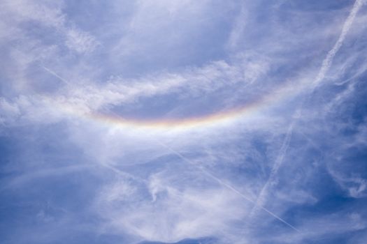 Circumzenithal arc against blue sky with white clouds seen in south of France near Marseille during summer 2019 (31st July 2019)