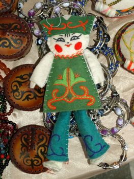Kazakh national handicraft doll over colored background.