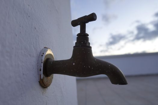 moroccan old faucet with a rustic color and white background.